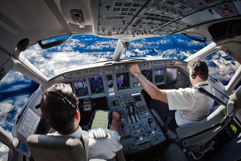 Piloter i et cockpit højt oppe over Jorden