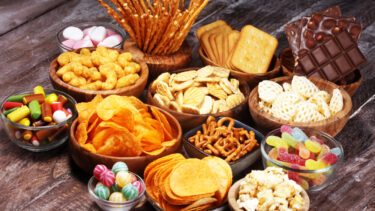 Et udvalg af forskellige snacks i skåle på et bord