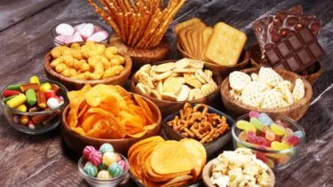 Et udvalg af forskellige snacks i skåle på et bord