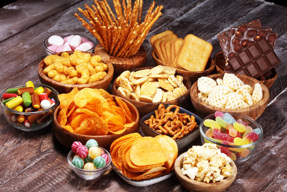 Et udvalg af forskellige snacks i skåle på et bord