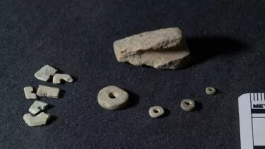 Rester af flint-bor og stenperler ligger ved lineal