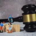 En hammer fra en domstol ved siden af tre figurer af arbejdsmænd.