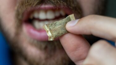 Mand holder snus foran sin mund
