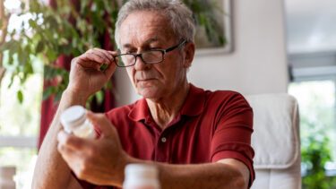 Ældre mand kigger på medicinglas