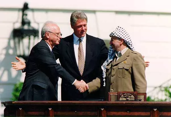 Israels premierminister Yitzhak Rabin, USA's præsident Bill Clinton og PLO-formand Yasser Arafat ved en ceremoni, der markerer underskrivelsen af fredsaftalen fra 1993 mellem Israel og palæstinenserne foran Det Hvide Hus.