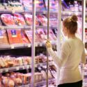 Kvinde ser på animalske fødevarer i supermarked
