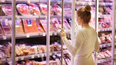 Kvinde ser på animalske fødevarer i supermarked