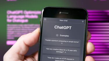 En hånd holder en iPhone med appen ChatGPT