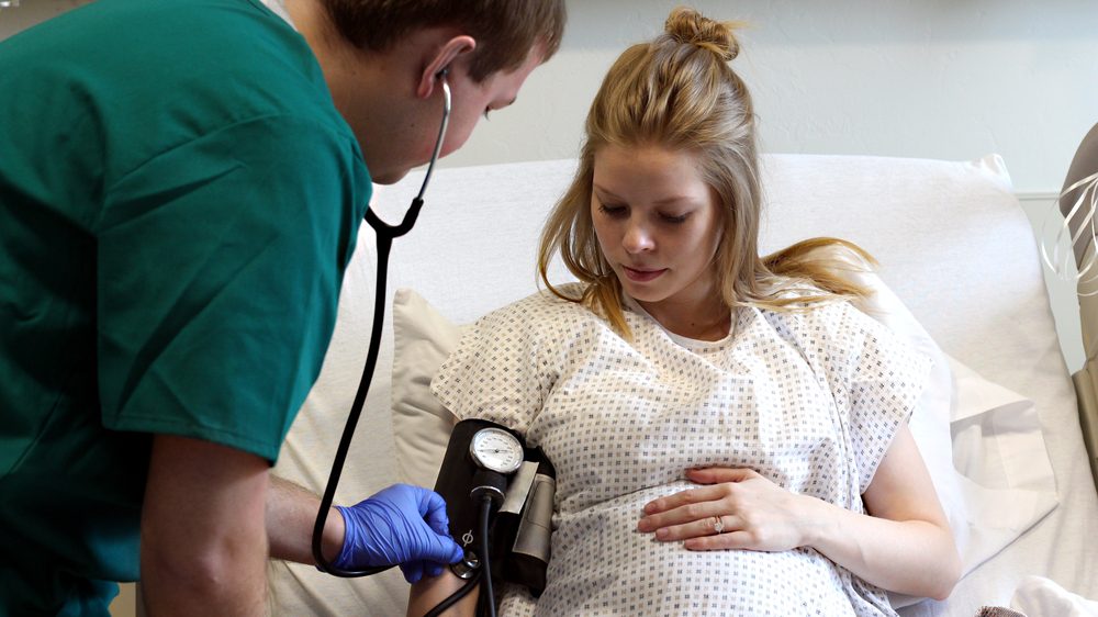Billede af en gravid kvinde, der får målt sit blodtryk på hospitalet.