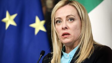 Italiens premierminister Georgia Meloni taler til en pressekonference i 2023 med et EU-flag i baggrunden.