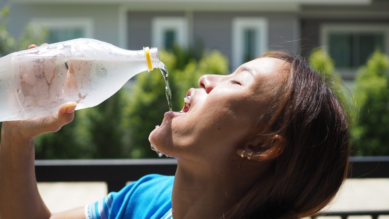 Kvinde drikker vand på en varm sommerdag