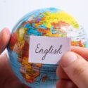 Person holder en globus med et skilt, hvorpå der står 'english