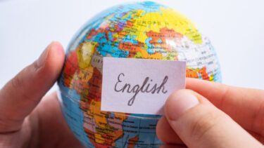 Person holder en globus med et skilt, hvorpå der står 'english