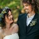 Brudeparret Rolf og Nina fra 'Gift ved første blik' smiler til hinanden. Hun er iført brudekjole og blomsterkrans i håret. Han er i jakkesæt og blomstret skjorte.