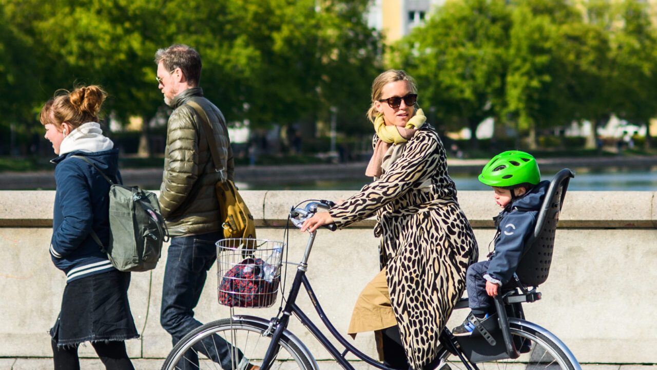 Barn bagpå mors cykel i morgentrafikken i København på Dronning Louises Bro.
