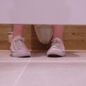 Fødder i en toiletbås, som man ser udefra