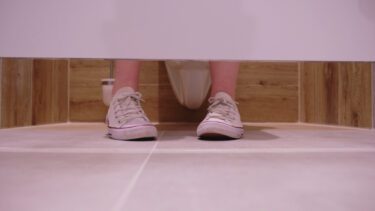 Fødder i en toiletbås, som man ser udefra