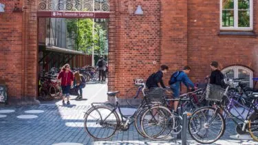 Indgangen til en dansk folkeskole med en masse børn udenfor