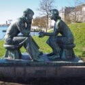 Stenskulpturer af to unge mennesker, der sidder overfor hinanden af Johannes Hansen.