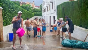 En gruppe af mennesker forsøger at tømme boligkompleks fra vand som følge af oversvømmelserne i Valencia, Spanien. (Foto: Shutterstock)