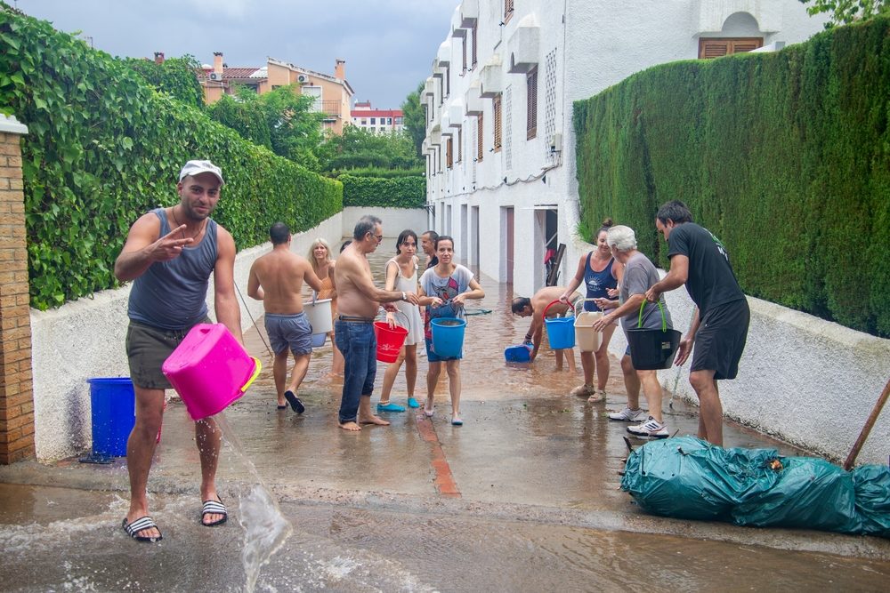 En gruppe af mennesker forsøger at tømme boligkompleks fra vand som følge af oversvømmelserne i Valencia, Spanien. (Foto: Shutterstock)