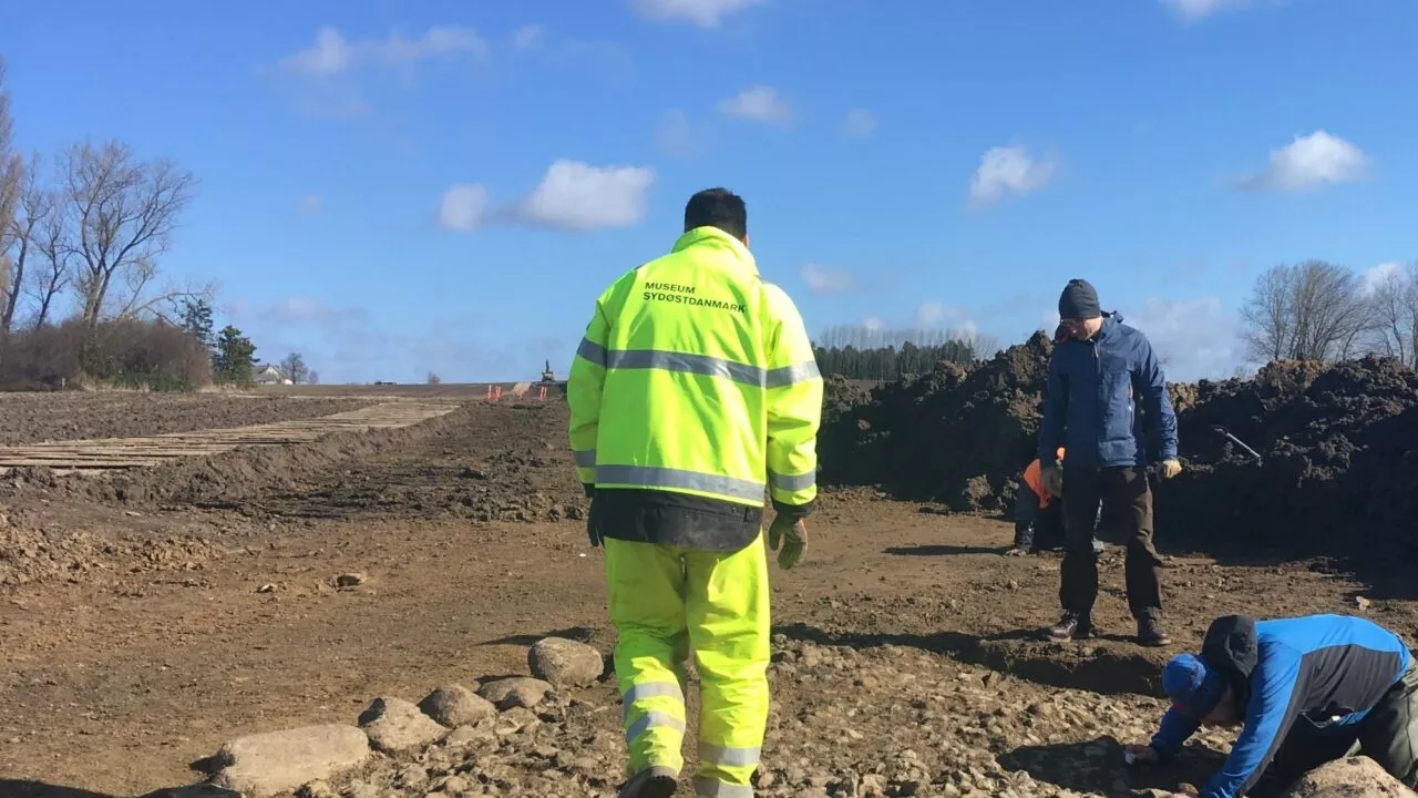 Arkæologer i refleksjakker udgraver vej fra jernalderen