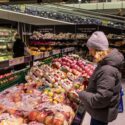 en kvinde i et dansk supermarked kigger på et æble