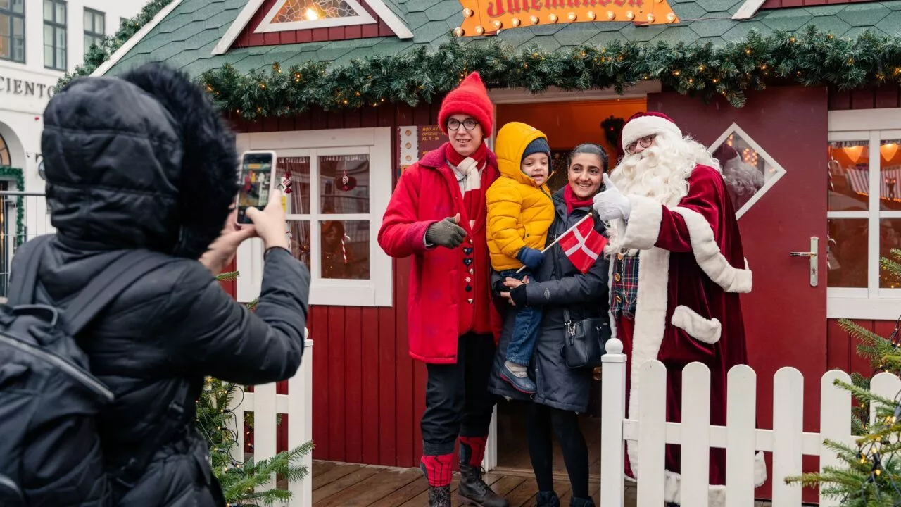julemanden foran sit hus i København med lille barn i armene på sin mor