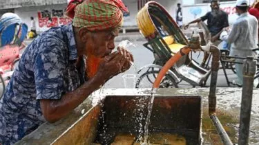En chauffør vasker sit ansigt i vejkanten i Dhaka, Bangladesh