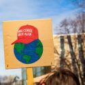 En klimademonstration med et skilt af en 'Make Climate Great Again' hat