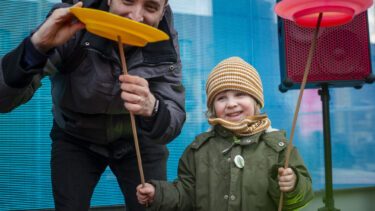 Far og barn leger med pind på tallerken til jonglering