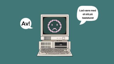 En computer med en smiley på skærmen, der har nedadvendt mund