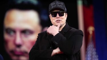 Elon Musk med solbriller og MAGA-hat foran billede af Elon Musk.