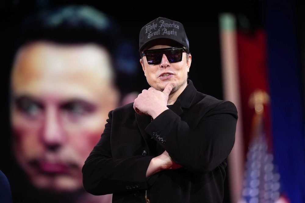 Elon Musk med solbriller og MAGA-hat foran billede af Elon Musk.