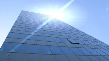 Kontorbygning set nedefra glimter i solen