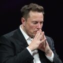 Elon Musk i tænksom mine med hænderne samlet foran ansigtet