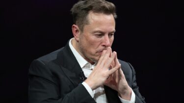 Elon Musk i tænksom mine med hænderne samlet foran ansigtet