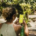 Ung pige holder en mobiltelefon i hånden. På skærmen er Snapchat-logoet.