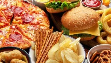 Foto af ultraforarbejdede fødevarer som pizza, kartoffelchips og popcon.