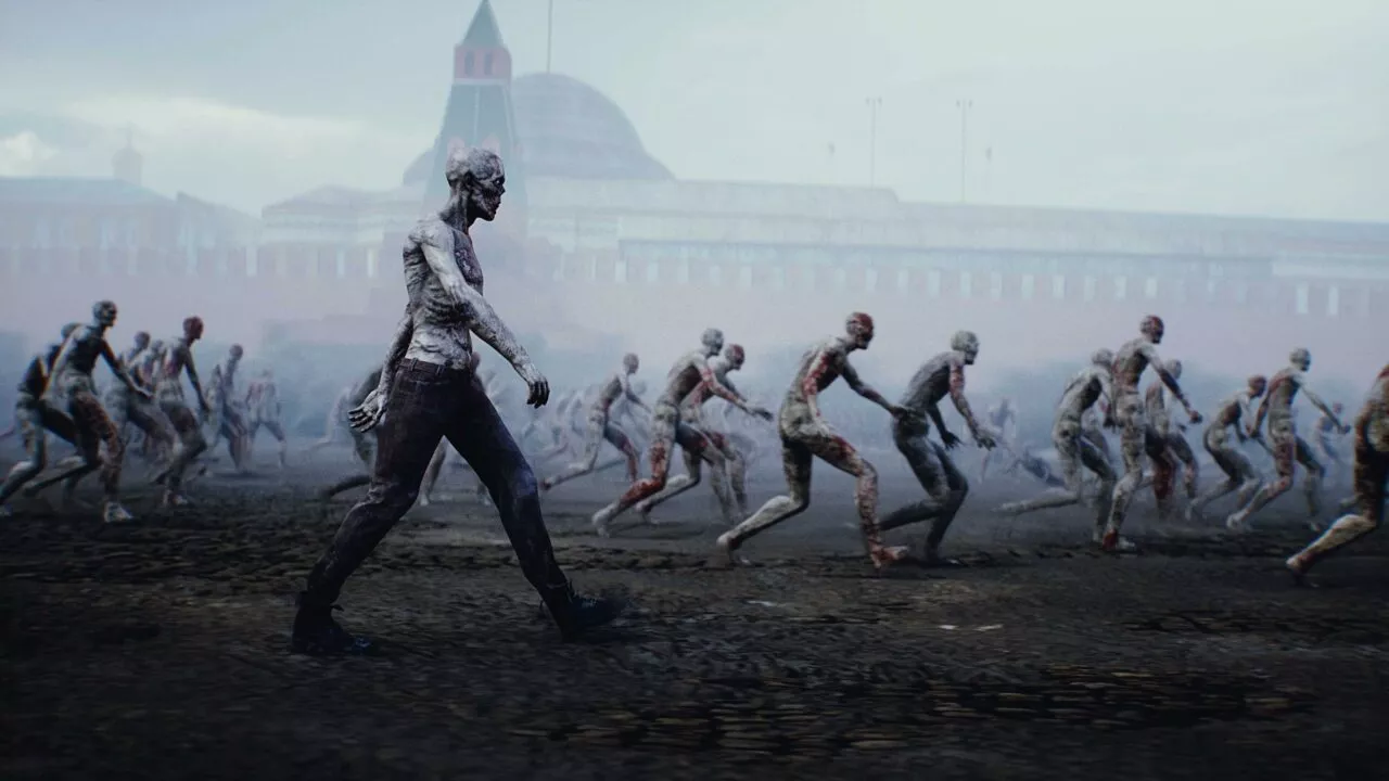 En gruppe zombielignende figurer med forrådnet, bleg hud går og vakler gennem et tåget, øde bylandskab med en stor, sløret bygning i baggrunden.