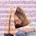 En ung kvinde sidder med hovedet hvilende på sine arme og ser trist ned. Billedet er overlejret af musiknoter og nodeark. Baggrunden er lyslilla.