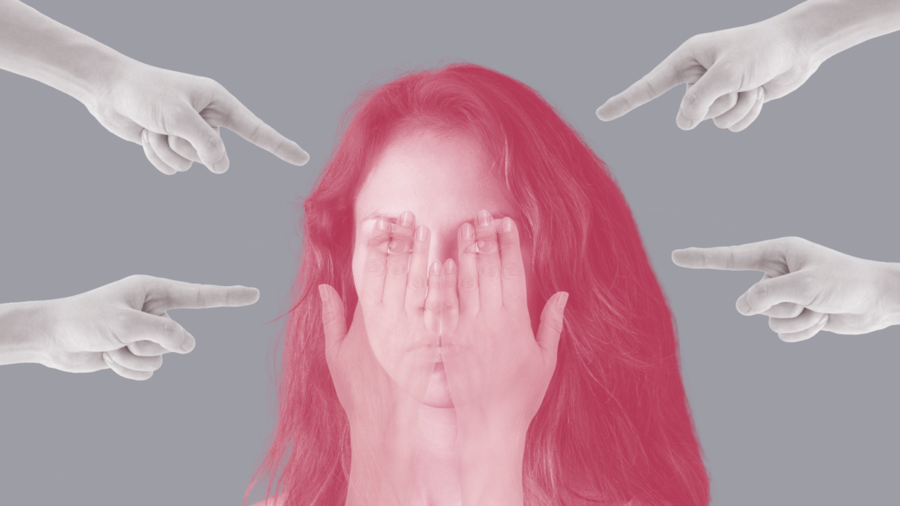 En kvinde, hvis øjne er dækket af hendes egne hænder, ser ængstelig ud. Flere hænder fra billedets kanter peger på hende mod en grå baggrund og symboliserer bebrejdelse eller dom.