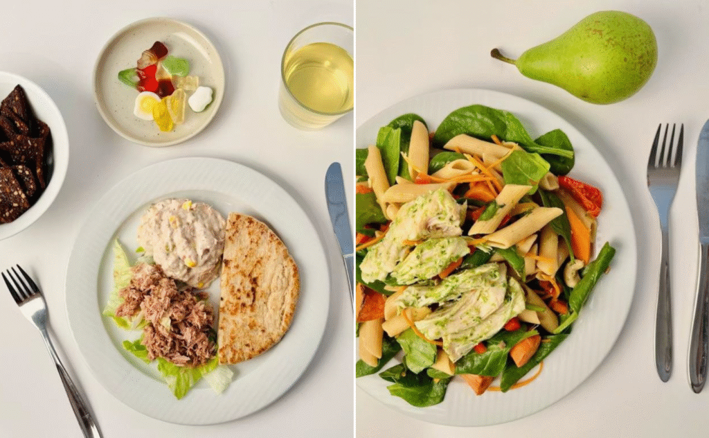 To dækkeservietter: På venstre tallerken er der tunsalat, almindelig tun og fladbrød med salat; slik og juice i nærheden. På højre tallerken er der pastasalat med grønt og kylling, og der ligger en pære, gaffel og kniv ved siden af tallerkenen.