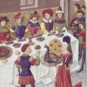 En middelalderlig banket-scene med elegant klædte mænd og kvinder, der sidder omkring et langt bord dækket med mad; en kvinde præsenterer en tilberedt påfugl på et fad, mens andre ser på eller serverer, alt sammen i et rigt dekoreret rum.