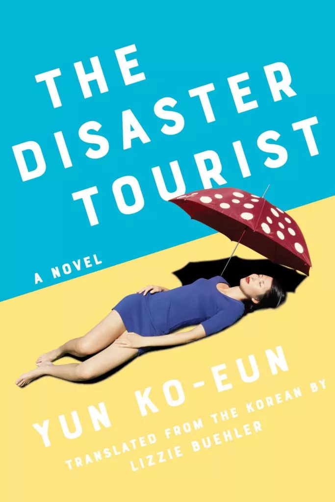 En kvinde i en blå kjole ligger på det gule sand og holder en rød paraply med hvide prikker. Baggrunden er halvt blå, halvt gul. Teksten lyder: »The Disaster Tourist«, Yun Ko-Eun, oversat af Lizzie Buehler.