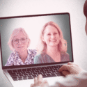 En person kigger på en laptopskærm, der viser to kvinder, som smiler under et videoopkald.