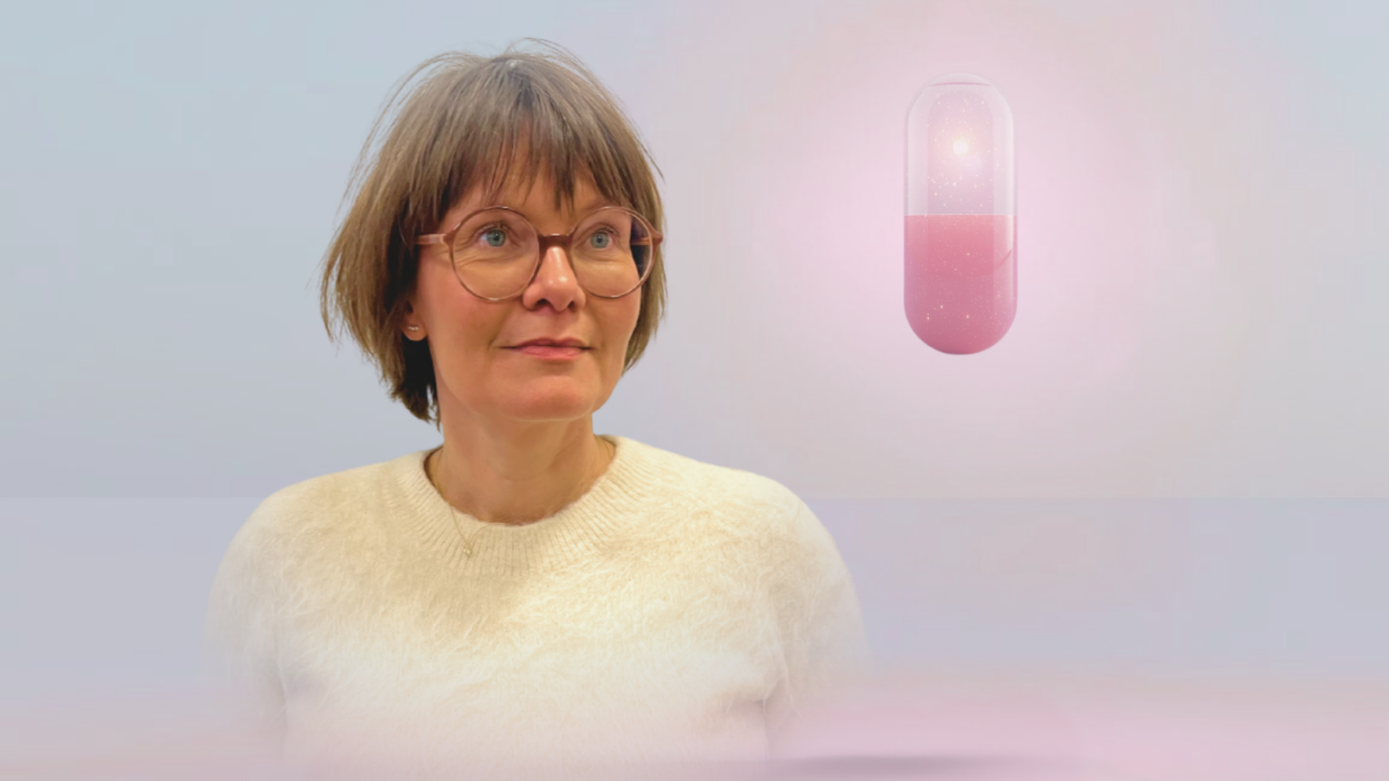 En kvinde med kort brunt hår og briller iført en cremefarvet sweater står foran en pastelfarvet baggrund med en stor, lysende pink kapsel svævende ved siden af sig.
