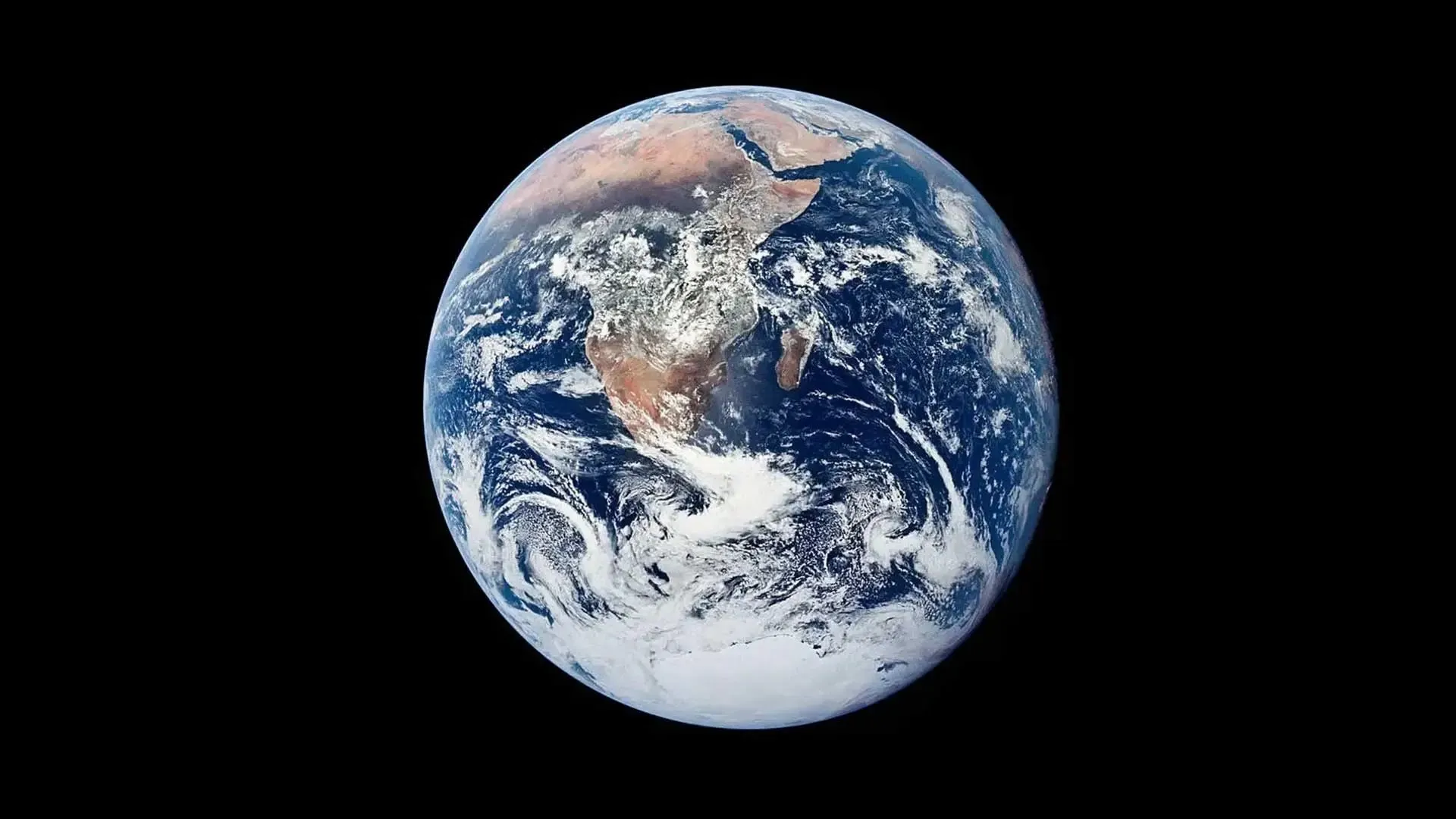 En udsigt over planeten Jorden fra rummet, der viser Afrika, dele af Europa, Mellemøsten og Det Indiske Ocean med hvirvlende skyer og blå oceaner mod en sort baggrund.