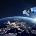 En satellit kredser over Europa om natten, hvor man kan se byernes lys over hele kontinentet, og solen står op over jordens krumning på en stjernefyldt himmel.