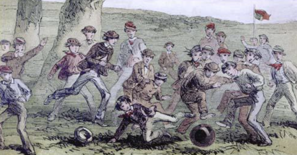 En gammel illustration viser en gruppe drenge, der spiller en livlig fodboldkamp udendørs, hvor flere spillere løber efter og sparker til en rund bold, mens andre løber rundt og hepper på græsbanen.